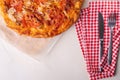 Hot homemade pizza with chicken meat, tomatoes, onions near with cutlery fork and knife on red tablecloth, flat lay, top view Royalty Free Stock Photo