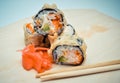 Hot homemade roll tempura shrimp and avocado lying next to the ginger, the concept of home Asian-inspired dinner.