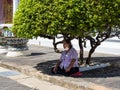 Thai woman resting in the shade under a tree at the Wat Arun Temple in Thailand, Bangkok