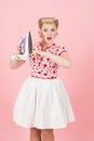 Hot Iron in hands of pin-up styled surprised blonde girl Royalty Free Stock Photo