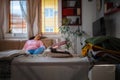 Hot iron on ironing board. In defocused background sleeping woman on sofa. Concept of fire hazard from electric Royalty Free Stock Photo