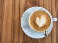 Hot latte and coffee beans in the coffee shop in the morning with heart-shaped milk foam