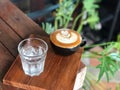 Hot latte coffee in Black cup and water glass on the vintage wooden table with natural light. Royalty Free Stock Photo