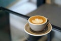 Hot Latte - A cup of coffee with milk and beautiful leaf pattern latte art on wooden table and copy space. Royalty Free Stock Photo