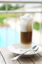 Hot latte on table near pool