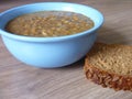 Hot lentil soup in a blue bowl with slife of bread