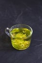 Linden flowers tea.Cup of hot herbal tea with linden fresh flowers on a black table Royalty Free Stock Photo