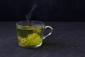 Linden flowers tea.Cup of hot herbal tea with linden fresh flowers on a black table Royalty Free Stock Photo