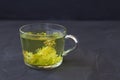 Linden flowers tea.Cup of hot herbal tea with linden fresh flowers on a black table Royalty Free Stock Photo