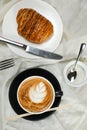 Hot Macchiato Coffee Latte Art served in cup with croissant, puff pastry, bread and knife isolated on napkin top view cafe Royalty Free Stock Photo