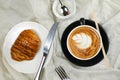 Hot Macchiato Coffee Latte Art served in cup with croissant, puff pastry, bread and knife isolated on napkin top view cafe Royalty Free Stock Photo