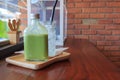 Hot matcha green tea in bottle and ice in glass on wood table. Royalty Free Stock Photo