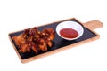 Hot Meat Dishes - Grilled Chicken Wings with Red Spicy Sauce. On a wooden board on a white background Royalty Free Stock Photo