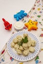 Hot meat dumplings with fresh sour cream. Homemade healthy kid`s food, funny toys Royalty Free Stock Photo