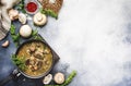 Hot meat vegetable mushroom soup with beef and wholegrain barley. With black bread, in metal pan, top view, gray kitchen table, Royalty Free Stock Photo