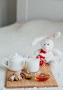 Hot milk in a glass cup and honey on wooden board. Treatment of children drink. folk remedies in bed. Soft toy Royalty Free Stock Photo