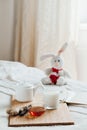 Hot milk in a glass cup and honey on wooden board. Treatment of children drink. folk remedies in bed. Soft toy Royalty Free Stock Photo