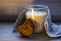 Hot milk in a glass and a chocolate chip cookie, by the window on a rainy day Royalty Free Stock Photo