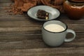 Hot milky drink, dark chocolate as a sweet winter snack.Cup of hot chocolate, pieces of chocolate on the saucer, knitted scarf on