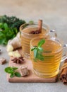 Hot mint and thyme tea with ginger root, lemon and honey, light concrete background. Herbal tea Royalty Free Stock Photo