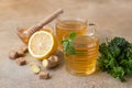 Hot mint and thyme tea with ginger root, lemon and honey, light concrete background. Herbal tea Royalty Free Stock Photo