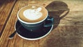 Hot mocha coffee or cappuccino in the blue cup with luxury pattern on the wooden table Royalty Free Stock Photo