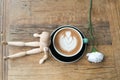 Hot mocha coffee or capuchino in the green cup lean by wood man on the wooden table Royalty Free Stock Photo