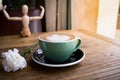 Hot mocha coffee or capuchino with white carnation flower and wood man on the wooden table Royalty Free Stock Photo