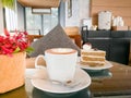 A hot mocha coffee with red orchid and mocha cake on the cozy coffee table Royalty Free Stock Photo
