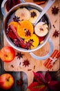 Hot mulled cider drink with citrus, apples, cinnamon sticks, cloves and anise in cooking pan