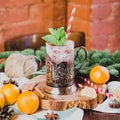 Hot mulled wine drink with lemon, apple, cinnamon, anise and other spices in a glass cup between fir tree branches on Royalty Free Stock Photo