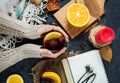 Hot mulled wine in female hands, spices on dark stone table. Sweet-home concept Royalty Free Stock Photo