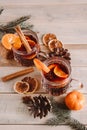 Hot mulled wine with spices in glass cup on wooden background. Christmas warming drink