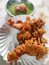 Hot onion bhajjiya bhajiya Indian fast food street food with green pudina chutney on paper plate ready to eat yummy tastey food Royalty Free Stock Photo