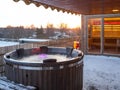 Hot outdoor wooden bath tub on terrace of private house. Finnish sauna Royalty Free Stock Photo