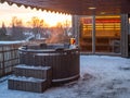 Hot outdoor wooden bath tub on terrace of private house. Finnish sauna Royalty Free Stock Photo