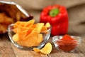 Hot pepper potato crisps - chips, fresh red pepper and package of chips in background