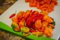 Hot Pepper, whole, chopped and sliced. Variety of fresh organic homegrown hot pepper and carrot, cut and uncut. Royalty Free Stock Photo