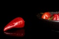 Hot pickled pepper isolated on black glass Royalty Free Stock Photo