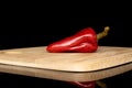 Hot pickled pepper isolated on black glass Royalty Free Stock Photo