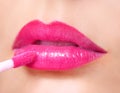 Hot Pink Lipstick. Lip Gloss on Lips and Brush Royalty Free Stock Photo