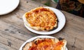 A hot pizza just coming out of a rustic outdoor bread oven.