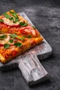 Hot pizza slices with mozzarella cheese, ham, tomato and parsley on wooden cutting board