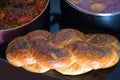 Hot plate for Sabbath with traditional food for Shabbat cholent and challah-special bread in Jewish cuisine.Top view.