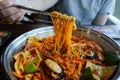 Hot pot of budae jjigae, korean instant noodles (ramyeon), pork, sausage, mussels and vegetables