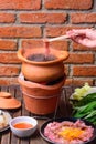 Hot pot with clear soup in the clay cooking pot. Royalty Free Stock Photo