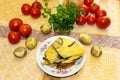 Hot ready moussaka is served on a porcelain plate among vegetables and spicy herbs. Fresh vegetables for cooking light dinner, Mo