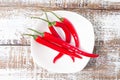 Hot red chili pepper in white plate on wooden table,top view,decorative Royalty Free Stock Photo