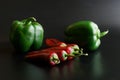 Hot red chili peppers and green bell peppers on a dark gradient background. The concept of a new harvest, the sale and cooking of Royalty Free Stock Photo