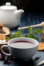 Hot red karkade tea with honey and mint. Autumn or winter soft drink. on blue wooden table